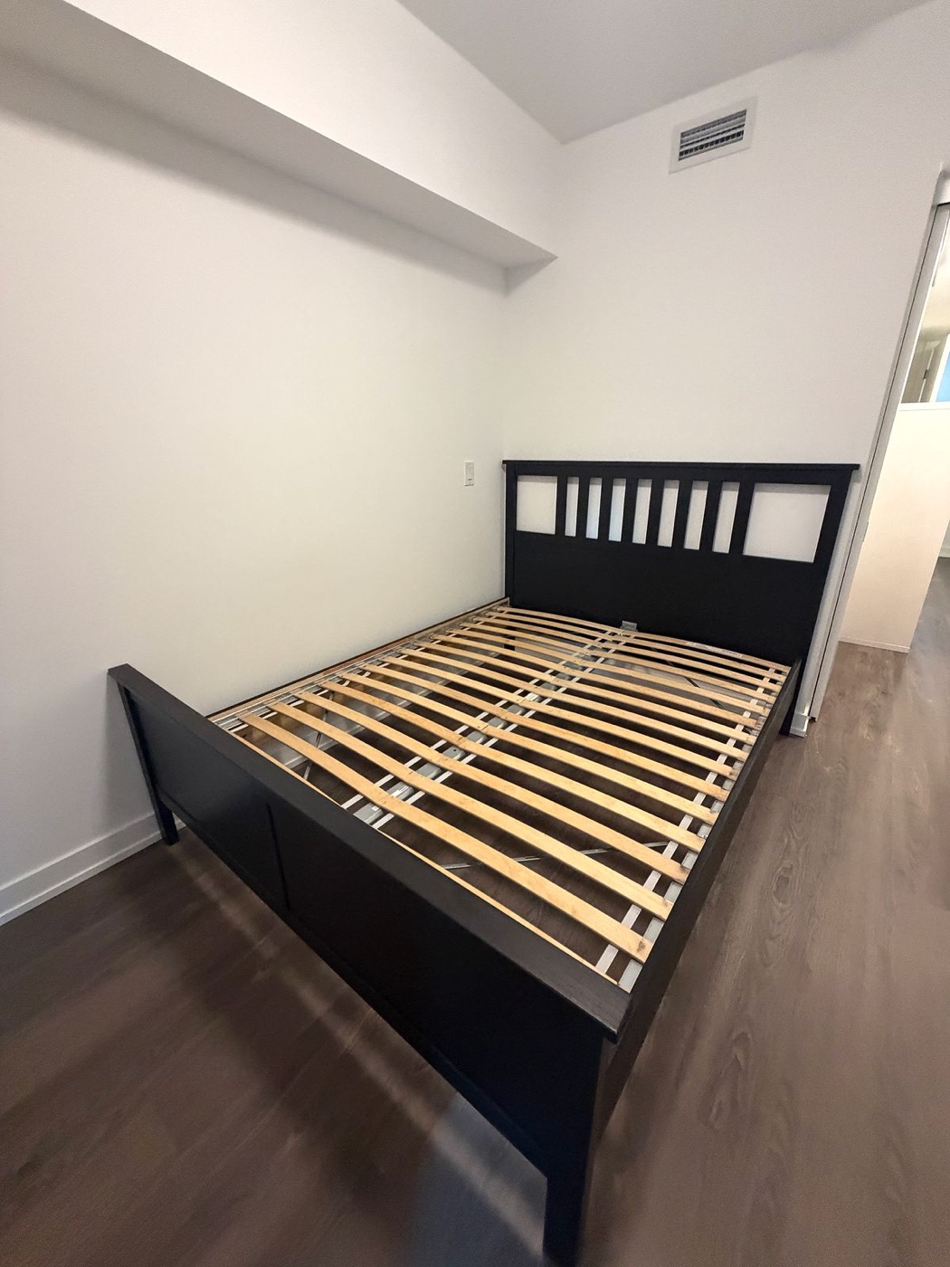 Black bed frame assembly in a condo bedroom